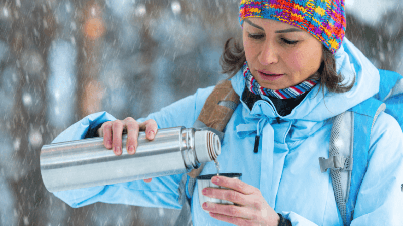 woman hiking in snow with insulated water bottle