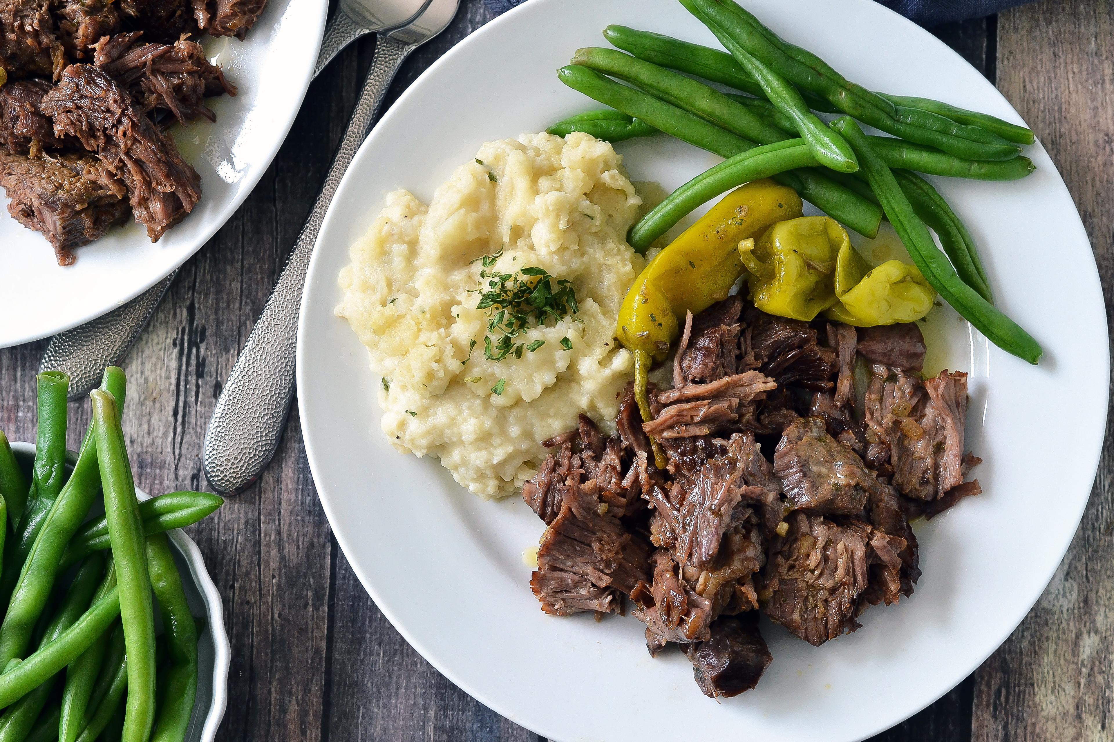 A full table spread with Chili-Pepper Beef Roast, mashed potatoes, and green beans, ready for a family meal