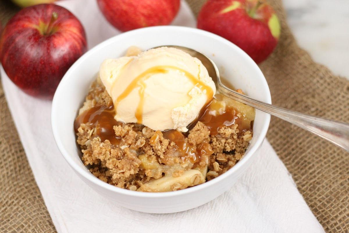 close-up of apple crisp with crunchy topping, steam rising, a spoon digging in, warm lighting