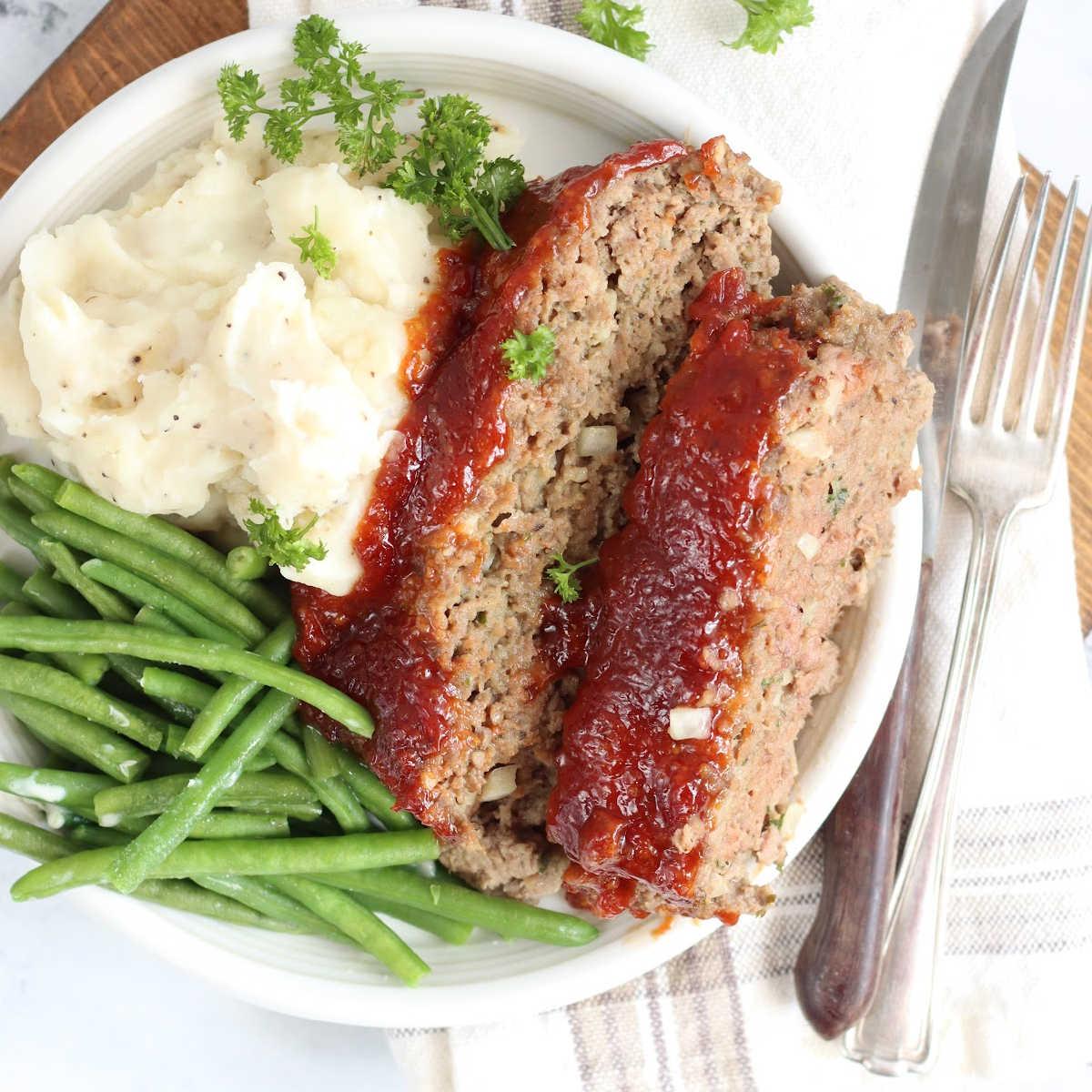 homemade meatloaf with mashed potatoes and green beans