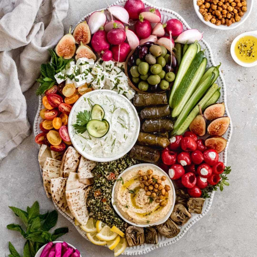 Overhead shot of a beautifully arranged Mediterranean mezze board with various dips and snacks