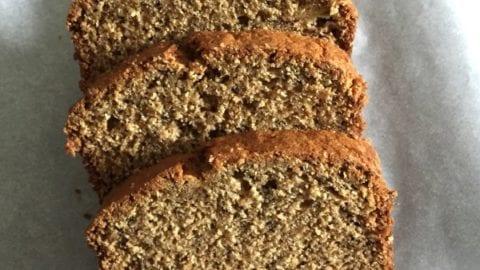 closeup of golden brown oatmeal banana bread loaf, steam gently rising