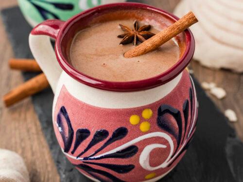 Close-up of a pot simmering Mexican hot chocolate with cinnamon sticks and star anise