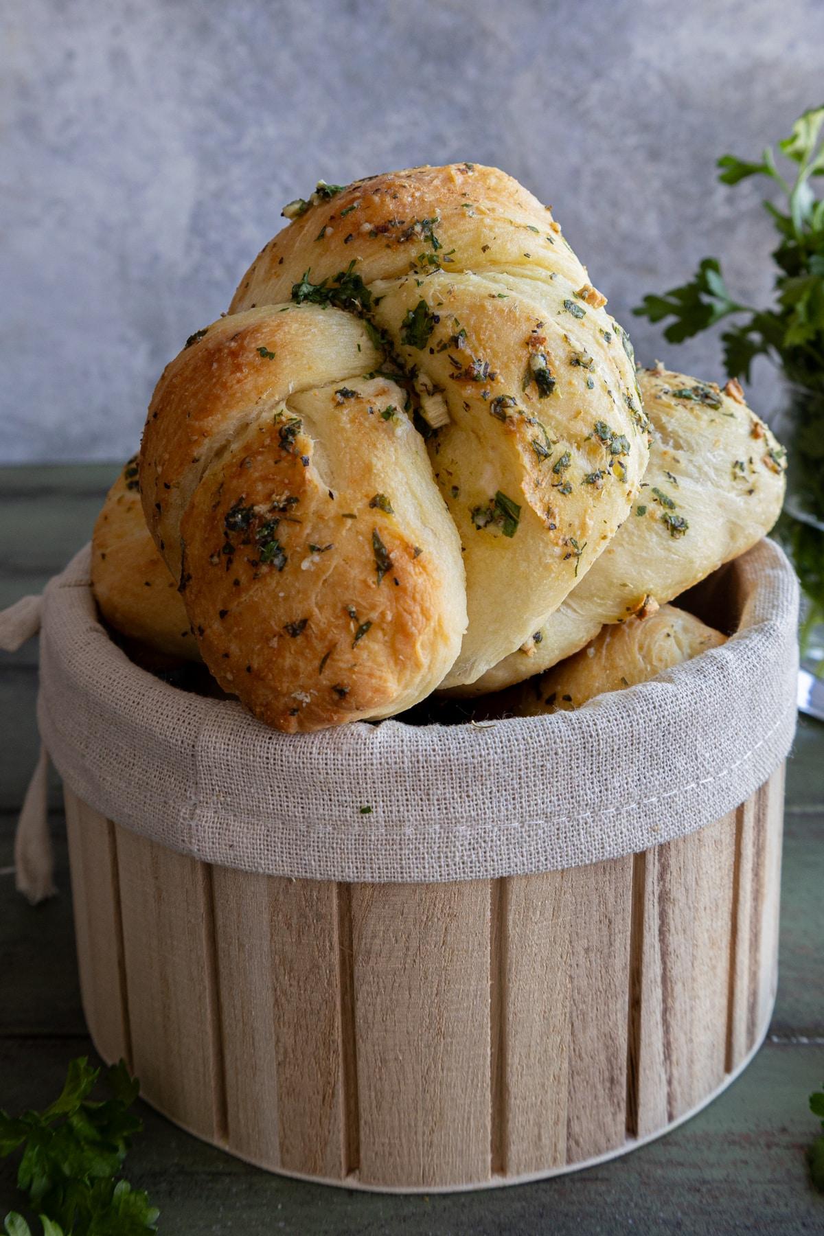 Parmesan garlic knots with soft crumb, warm and golden brown on a wooden board