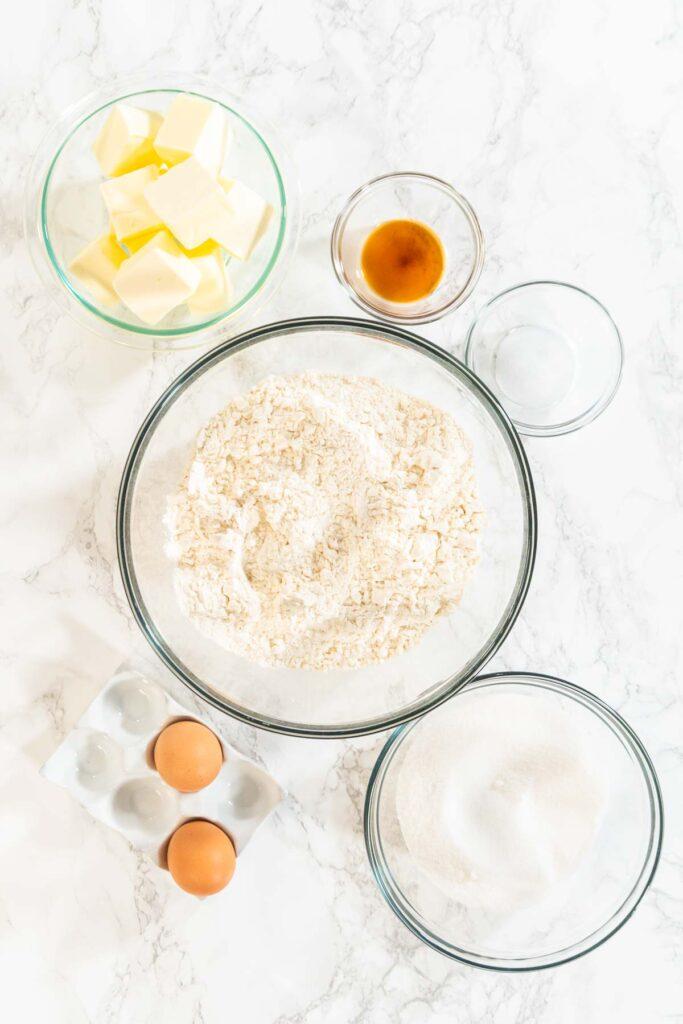 overhead shot of a kitchen counter with flour, butter, and rolling pin ready for sugar cookie baking