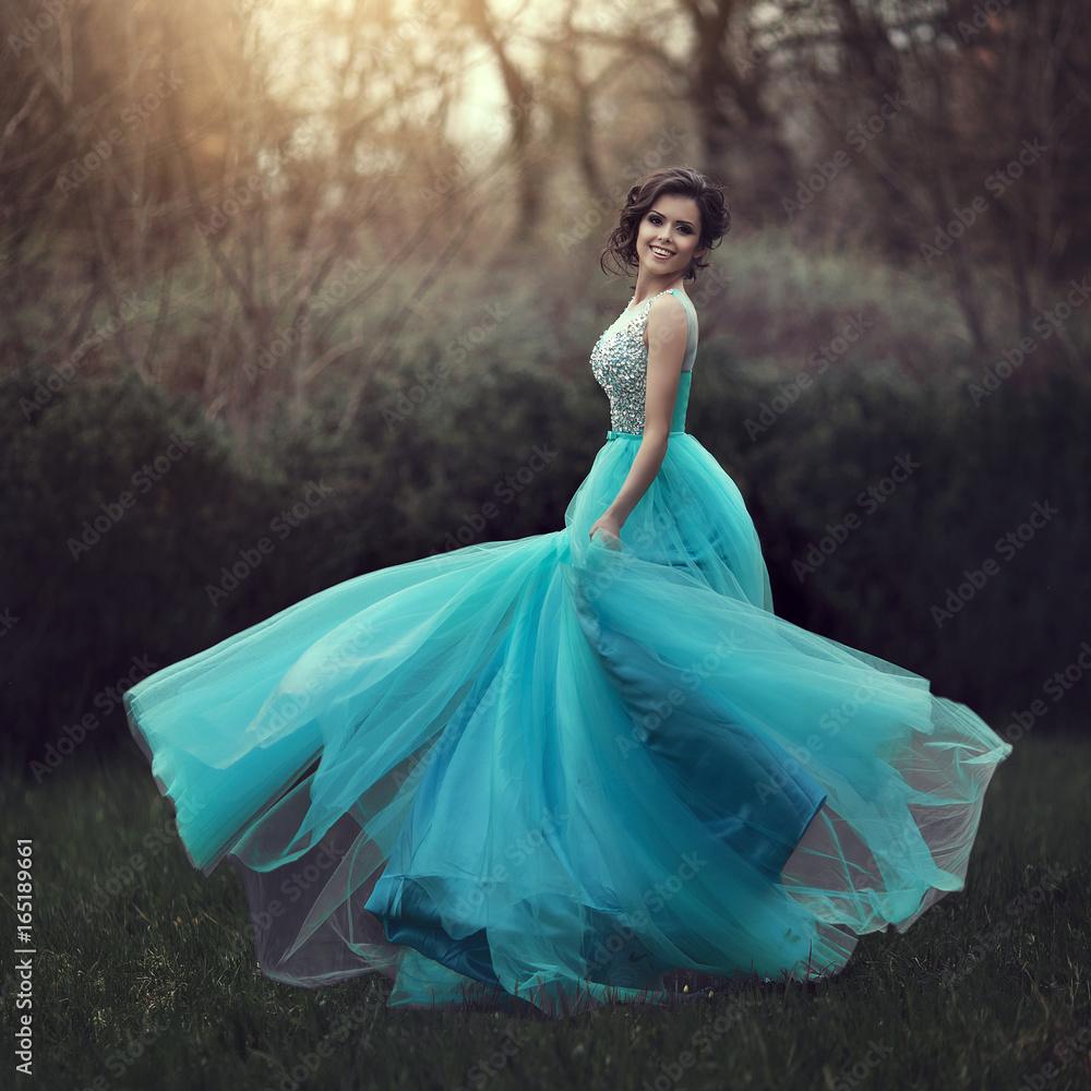 A girl twirling in the Celestial Dream prom dress, smiling at the camera