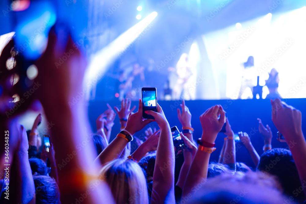 people using phones at a music festival