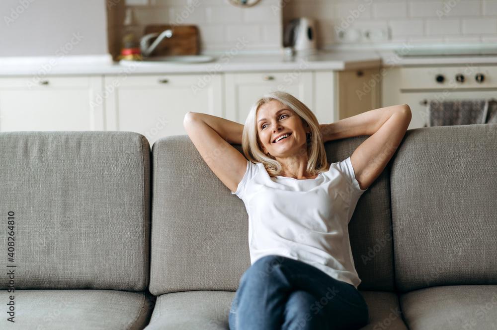 Woman relaxing on a couch, looking happy