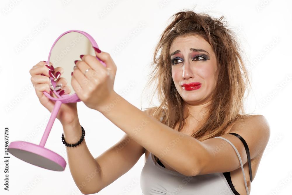 woman frustrated with melting makeup looking in mirror