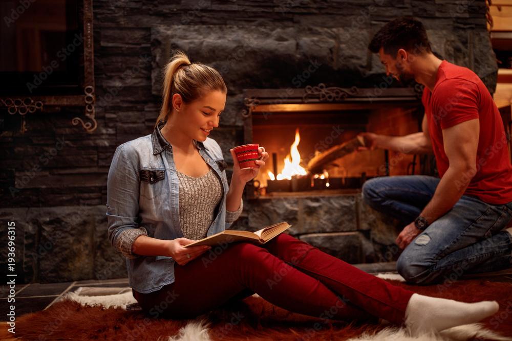 couple relaxing at home by fireplace