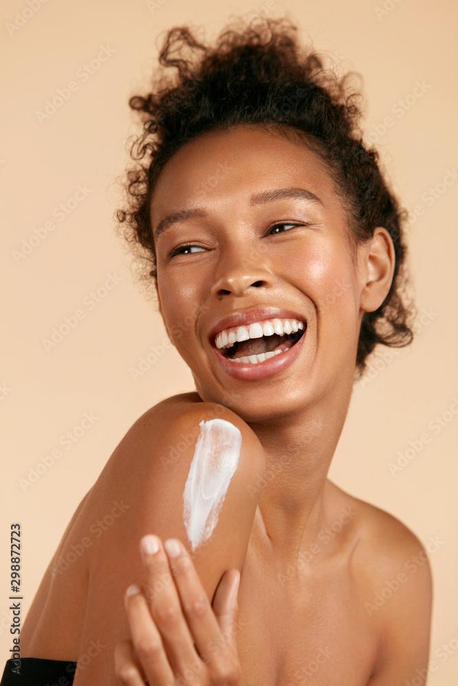 woman with soft, hydrated skin applying body lotion