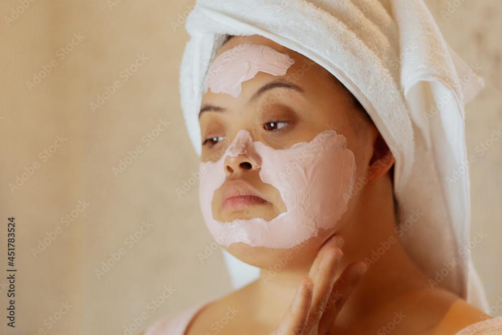 woman applying face mask in bathroom