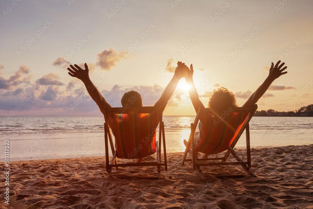 couple holding hands and enjoying sunset on beach