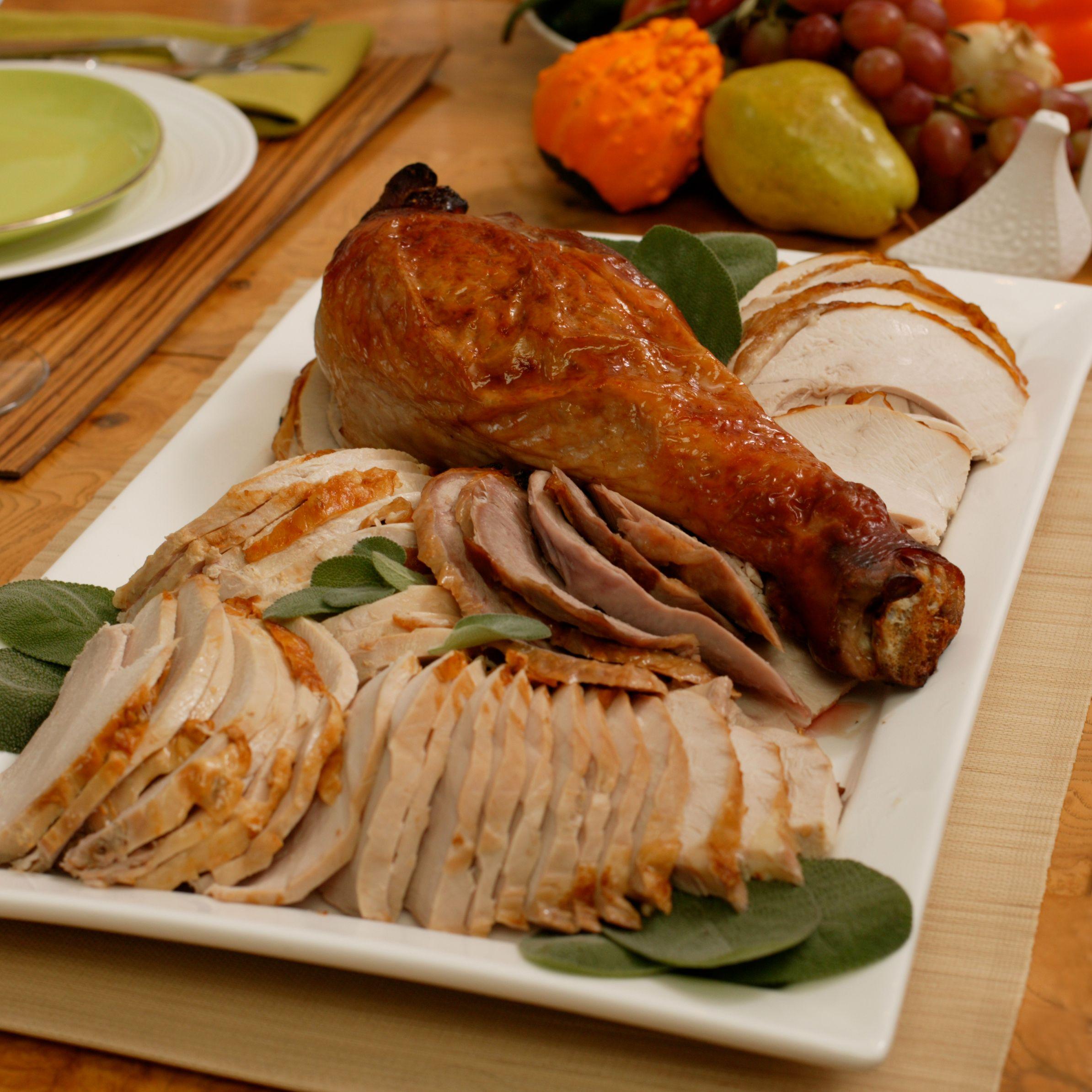 Whole roasted sage butter turkey with rich pan gravy on a festive table, close up