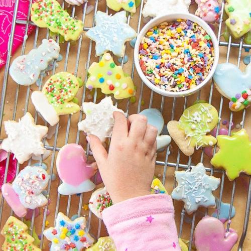 Happy family sharing freshly baked sugar cookies with milk