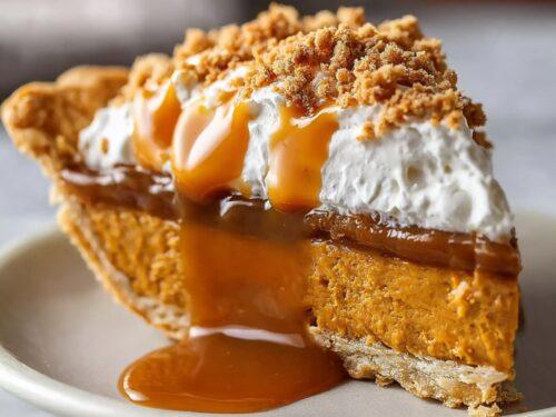 Warm slice of rustic pumpkin pie with caramel drizzle on an autumn table setting