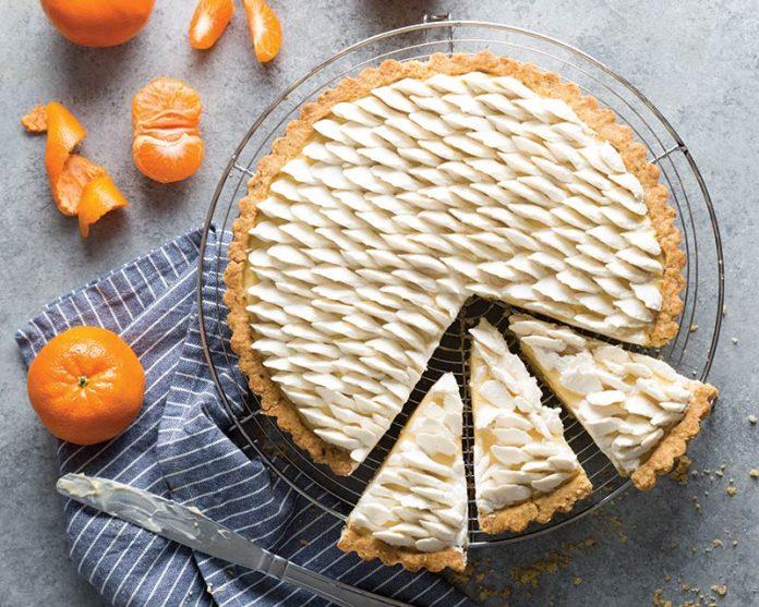 overhead shot of a beautifully sliced Tangerine & Cardamom Tart, highlighting the creamy filling and citrus segments