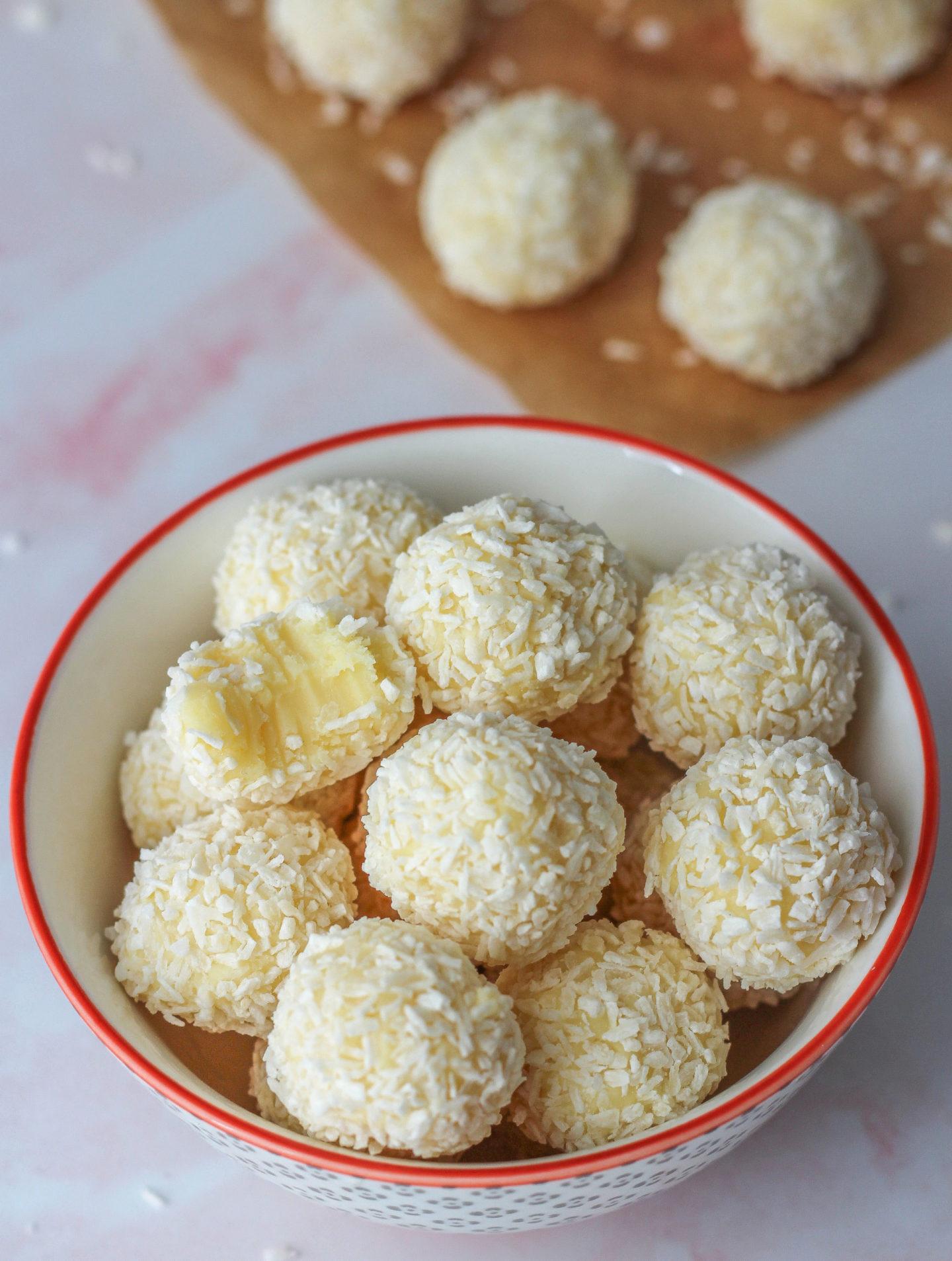homemade coconut truffles with creamy white center, dusted with coconut flakes, on a beautiful serving platter