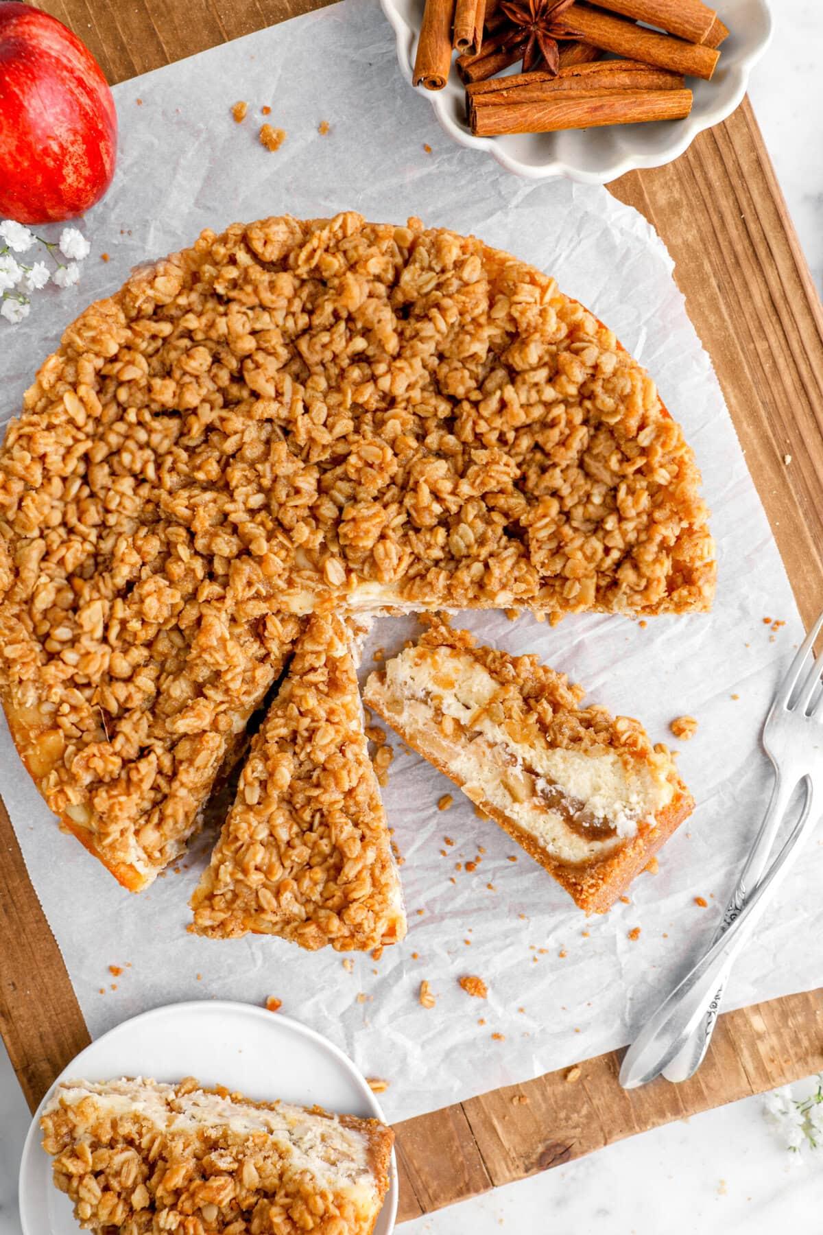overhead shot of an apple crumble cheesecake with a slice cut out