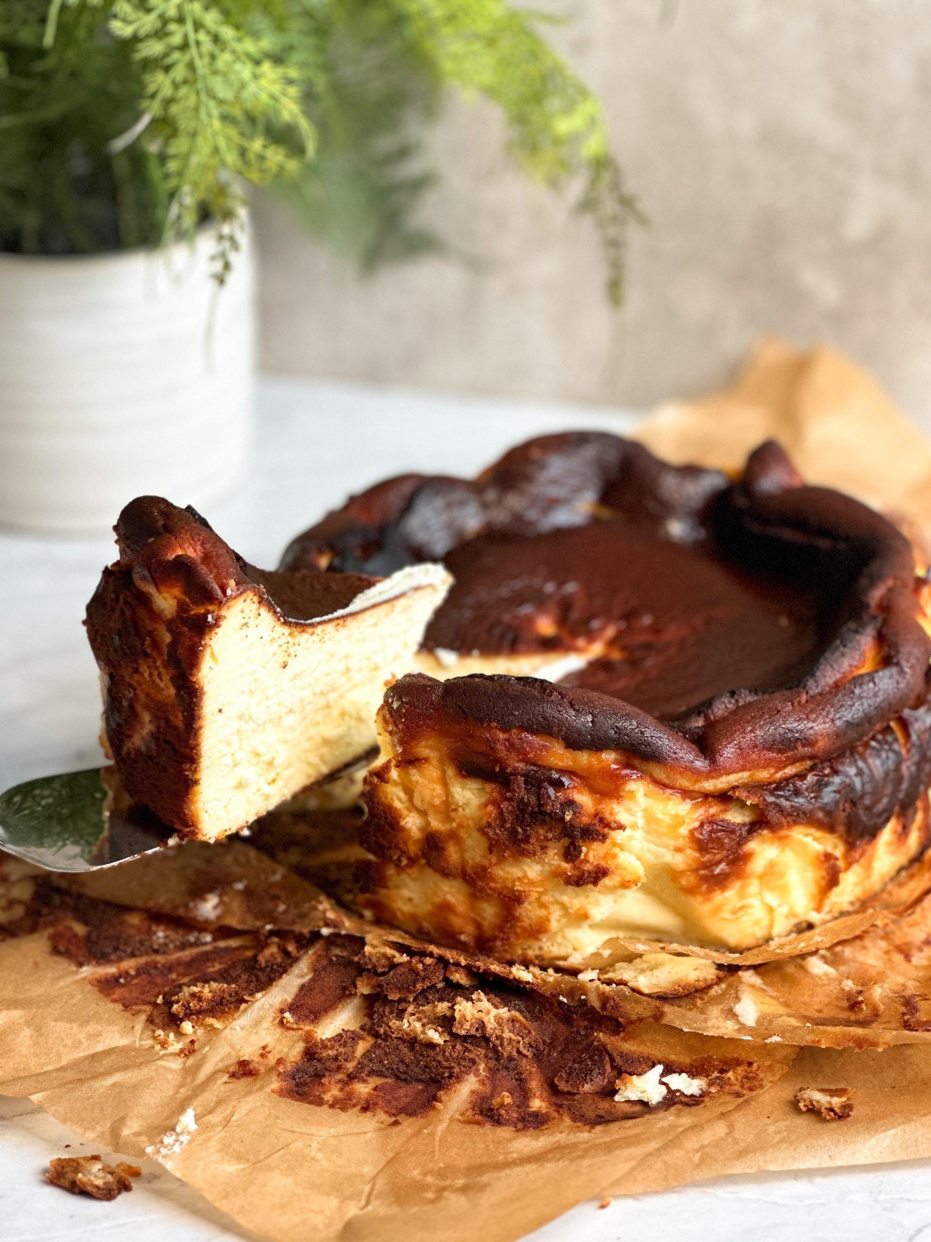 hands gently slicing a piece of cheesecake, revealing its dense and creamy interior