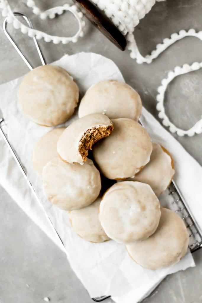 Close-up shot of an iced ginger cookie with a bite taken out, showing chewy interior
