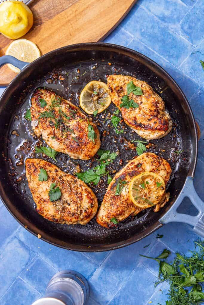 Golden seared chicken pieces in a cast iron pan, ready to be added to curry