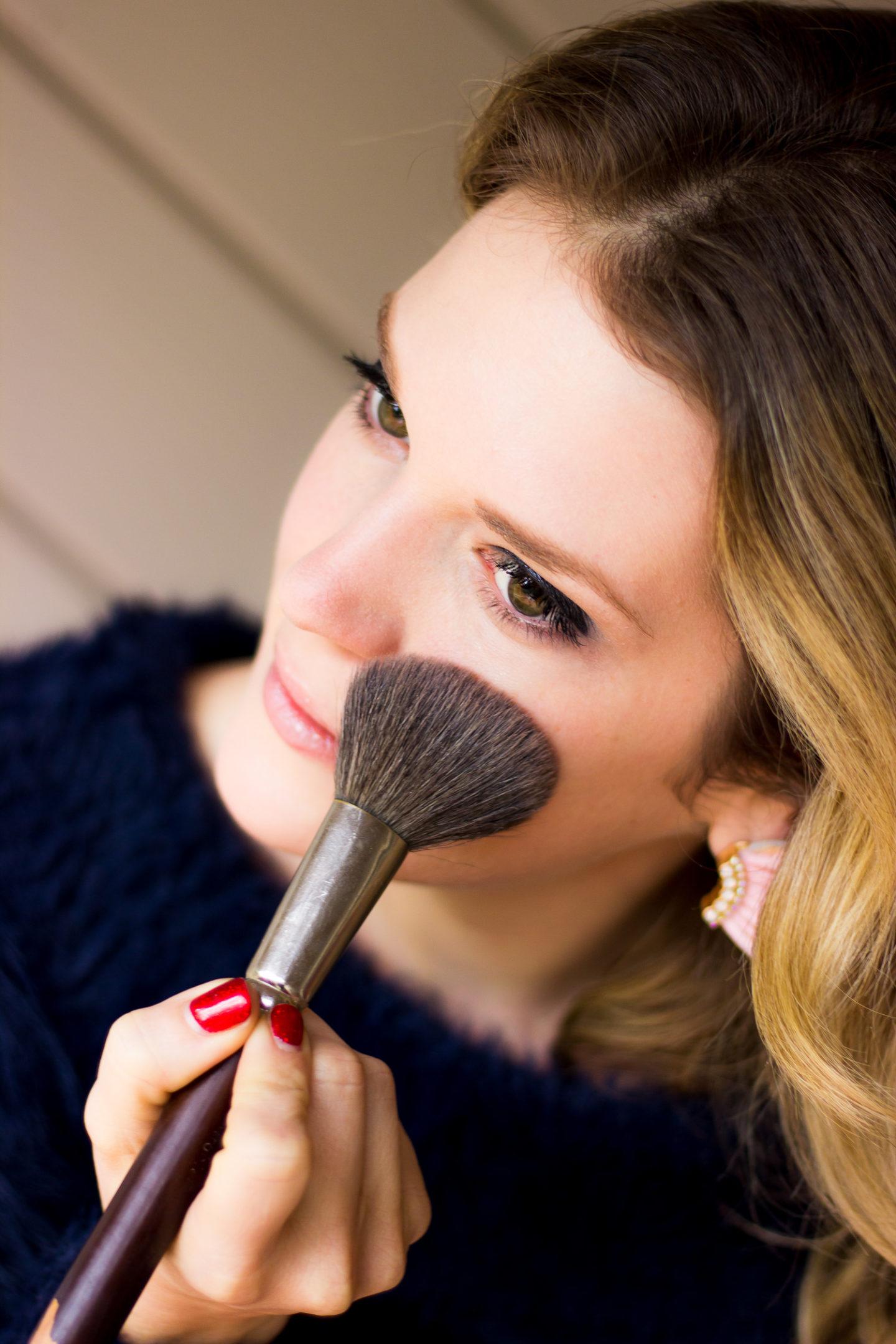 woman applying glitter makeup with a brush