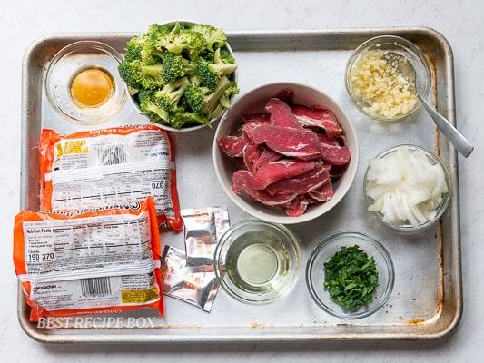 ingredients for beef and broccoli ramen laid out on a table