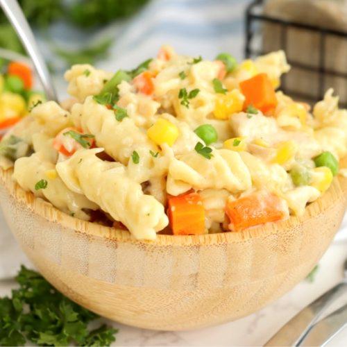 ingredients for mac and cheese crust pot pie laid out, cheese, pasta, chicken, vegetables