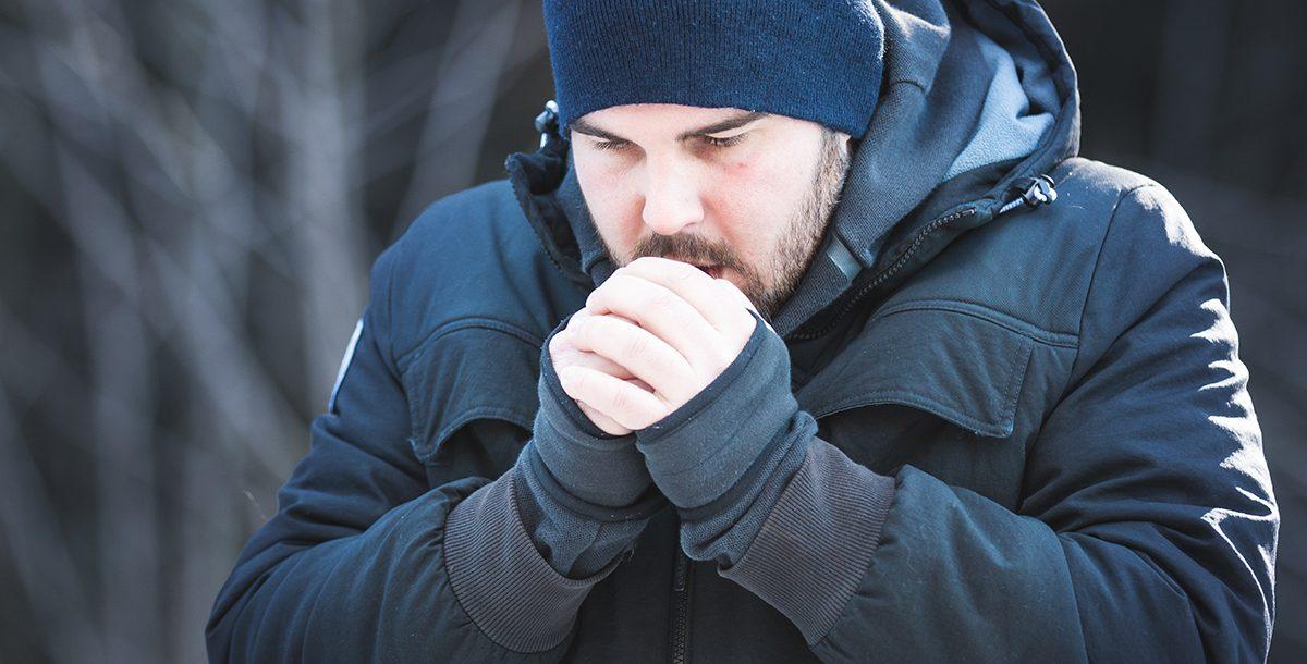 person shivering while hiking in winter