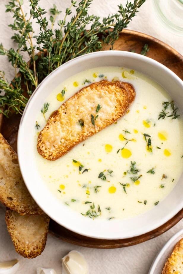 garnish creamy parmesan garlic soup with fresh parsley, serving with crusty bread slices