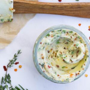 Close-up of butter and fresh herbs being mixed in a bowl