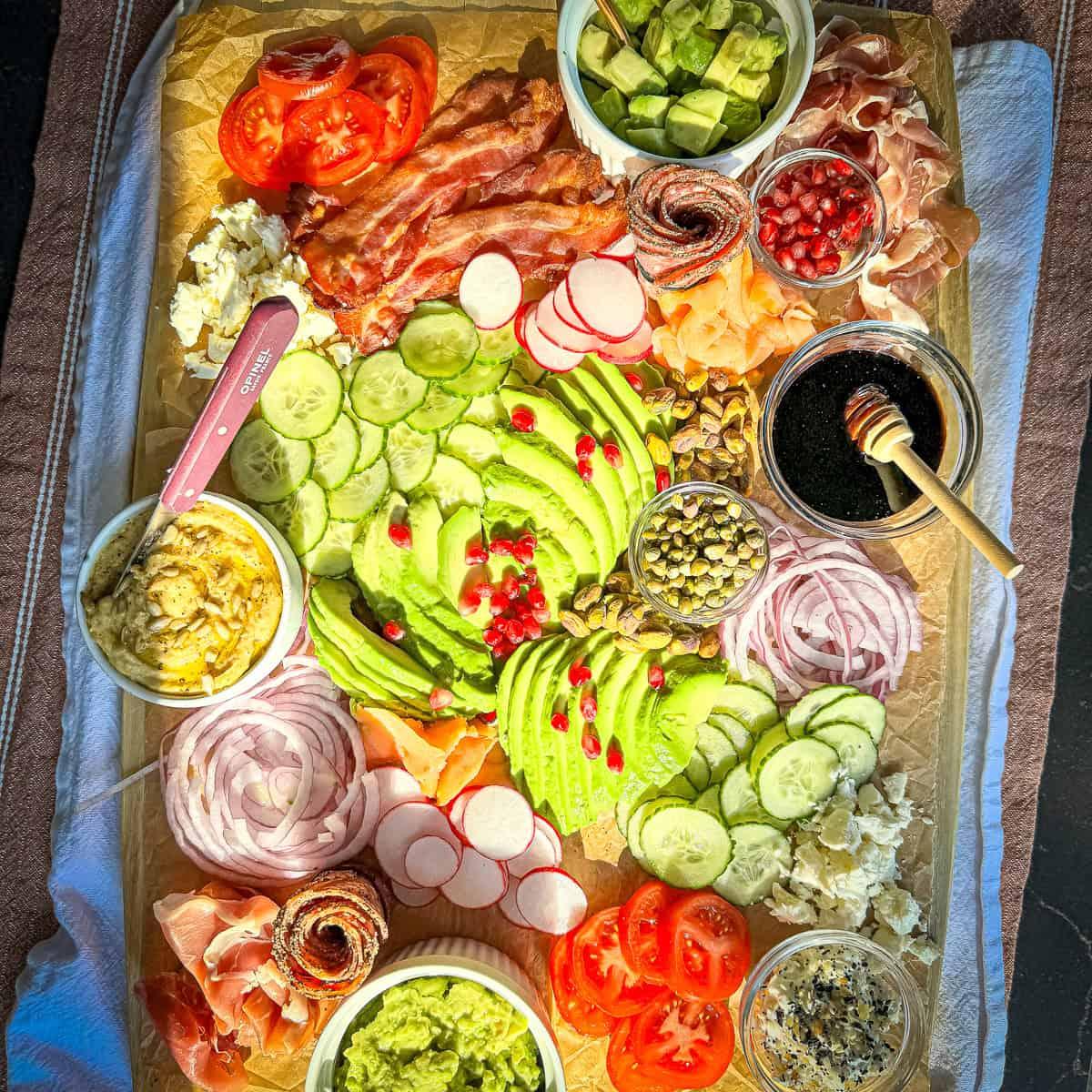 different fresh ingredients for an avocado dinner plate laid out on a cutting board