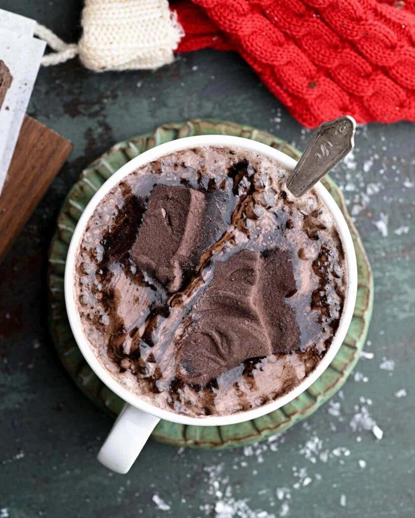 close-up of melted dark chocolate in a bowl, with marshmallows waiting nearby
