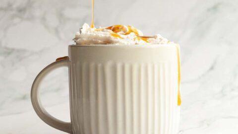 Close-up of a mug of salted caramel hot chocolate with whipped cream and caramel swirl