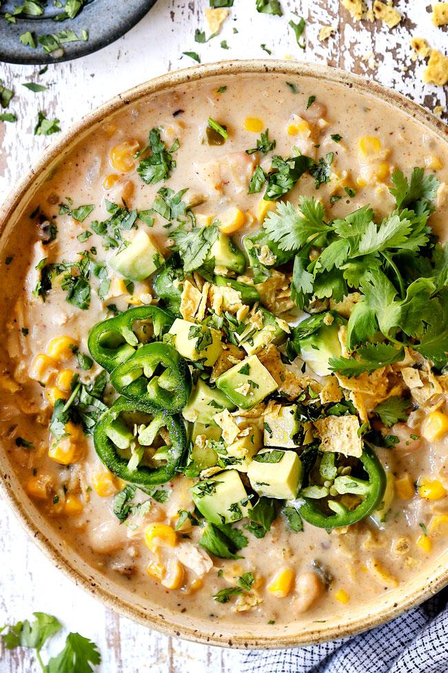 Ingredients for white chicken chili laid out: cooked chicken, cannellini beans, corn, cream cheese, green chilies, spices