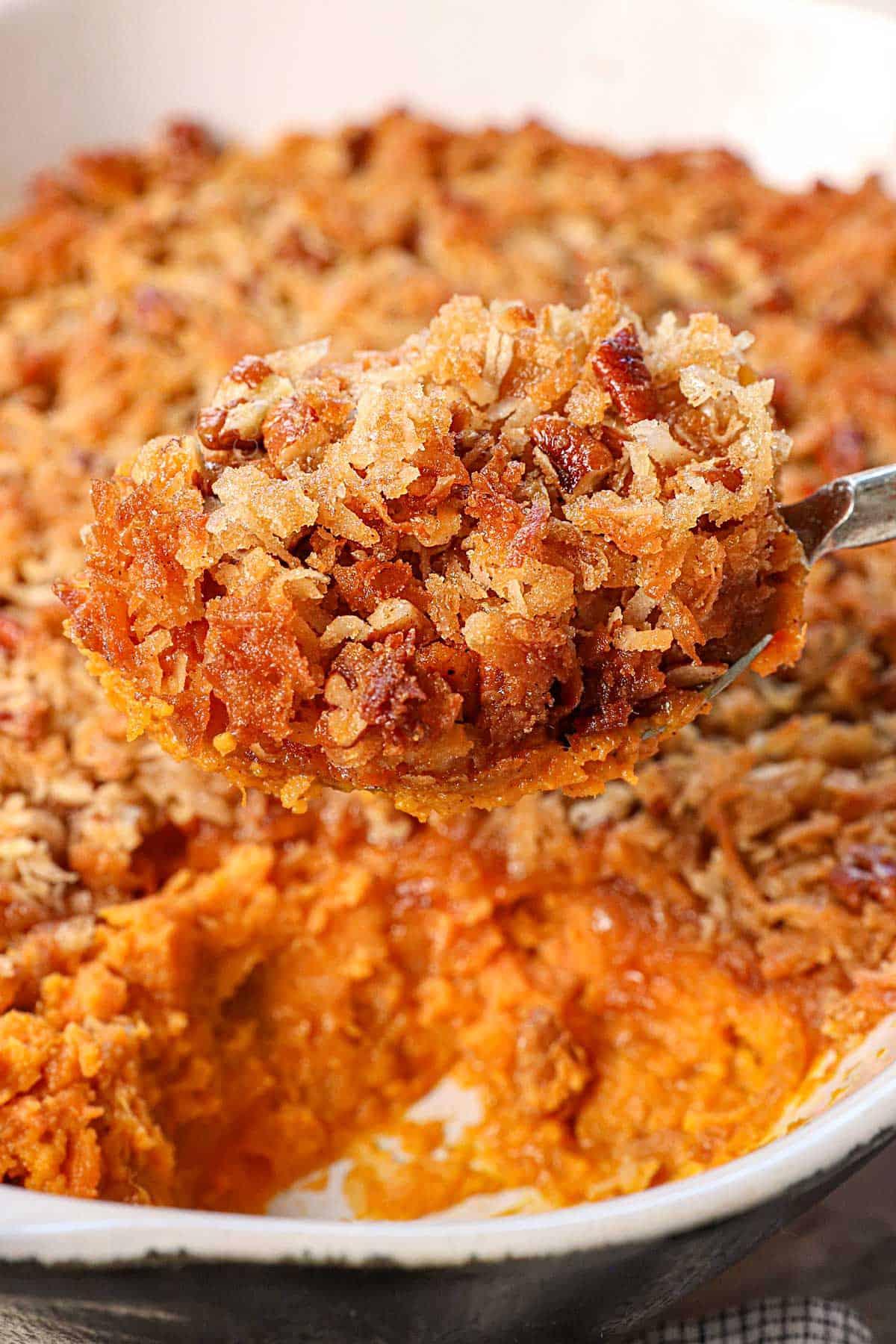 Close-up of golden sweet potato casserole with toasted coconut topping, holiday setting