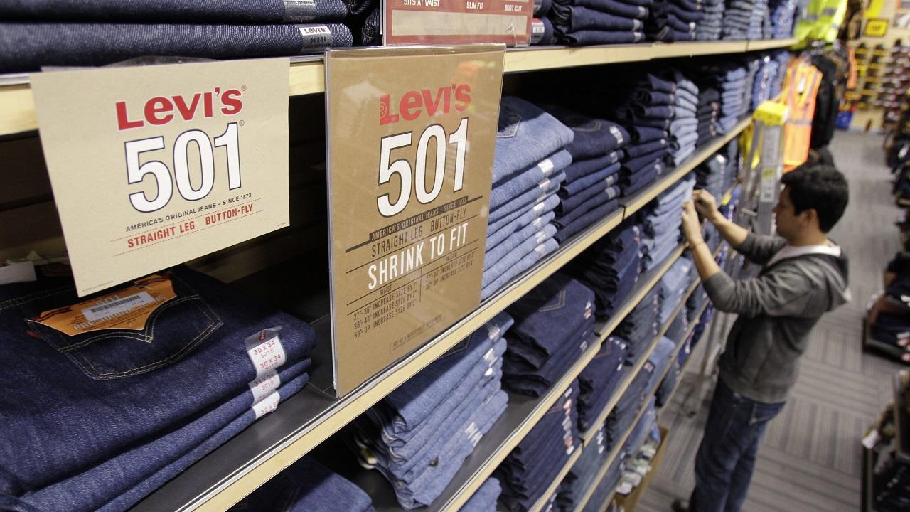 A pair of Levi's 501 jeans displayed on a shelf in a store.