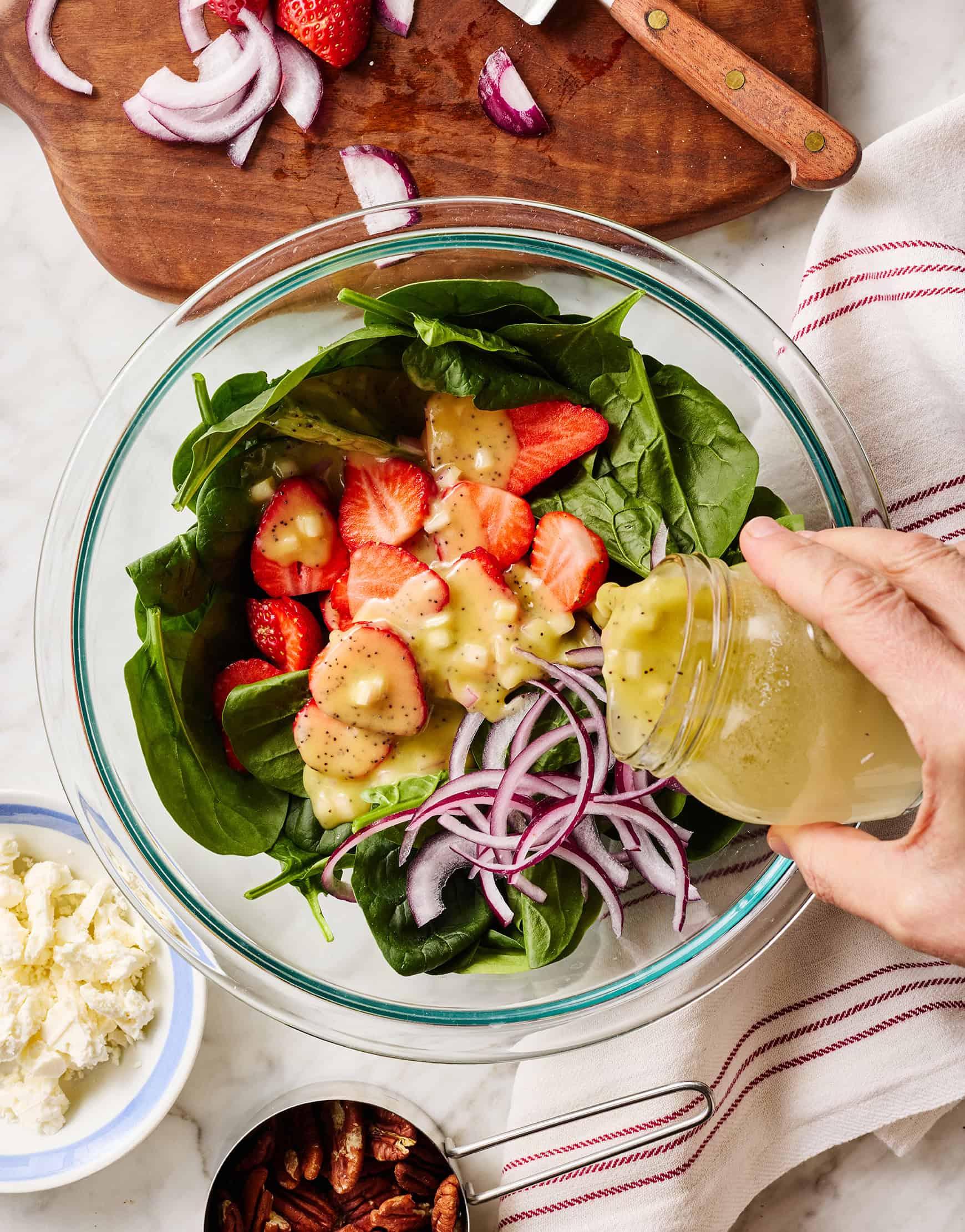 side view of strawberry spinach salad with marjoram flowers in a bowl