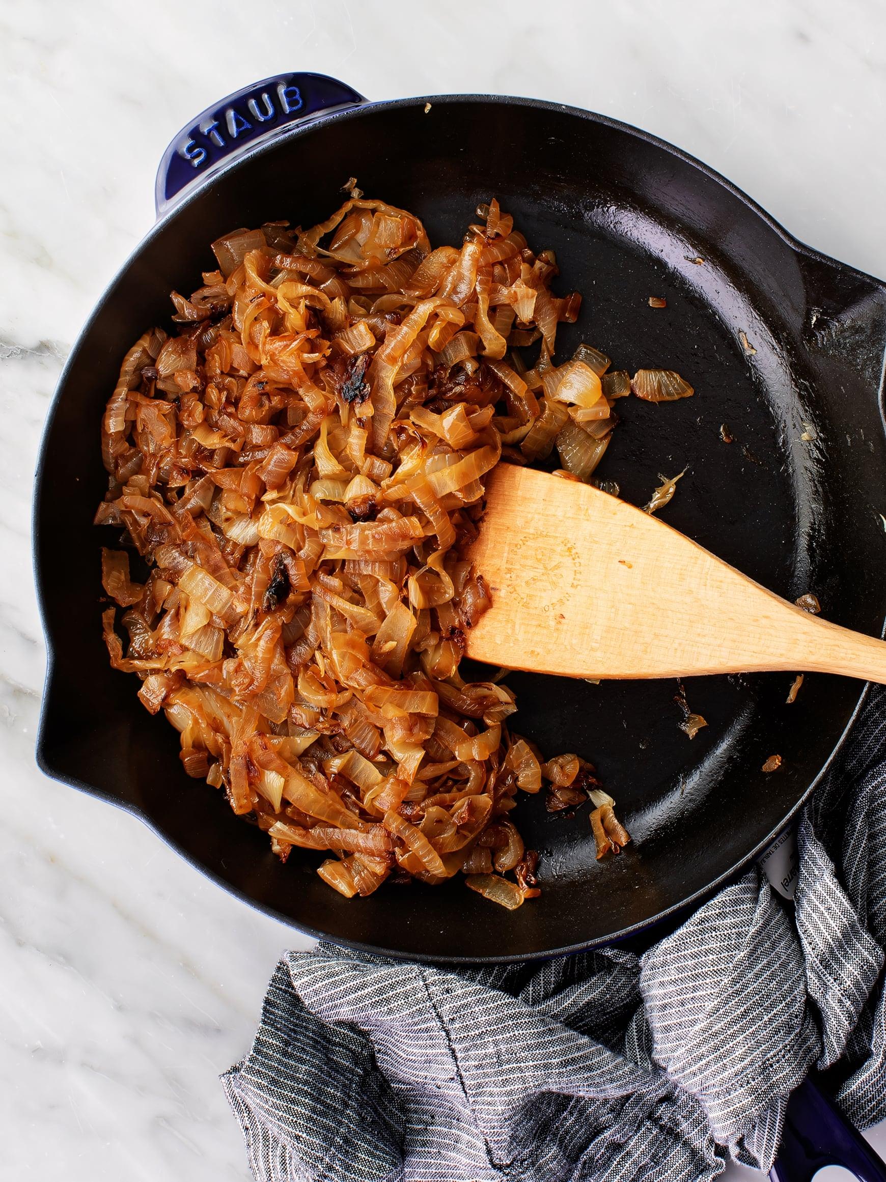 Pile of sliced yellow onions ready for caramelization in a large pot