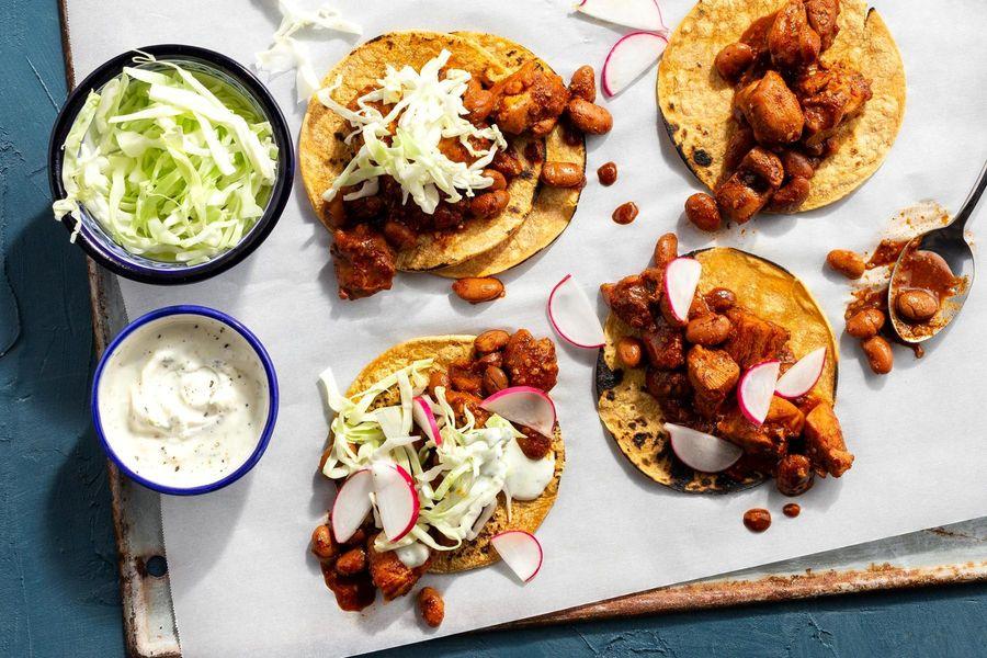 Oaxacan mole chicken tacos with fresh cilantro and lime wedges
