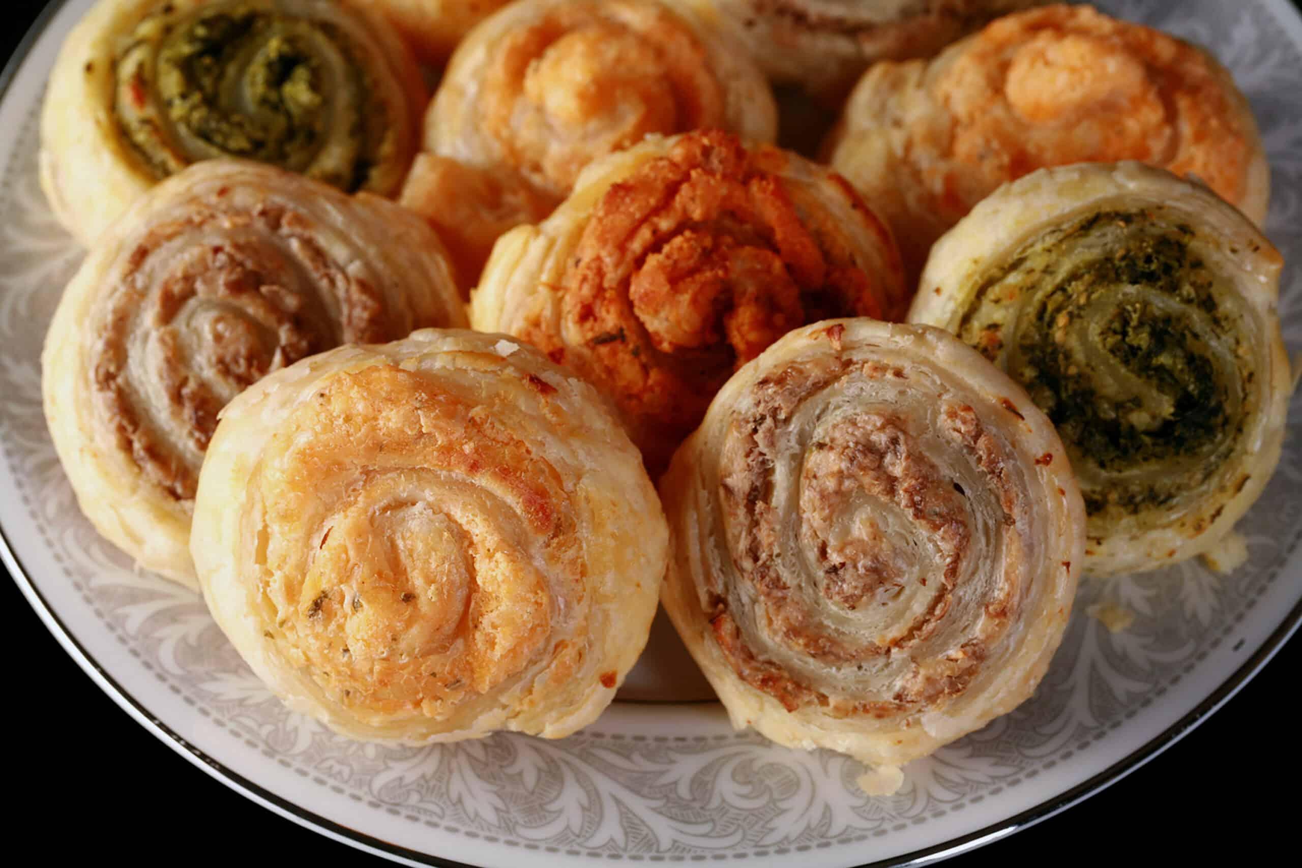 Close-up of golden brown puff pastry pinwheels on a cooling rack, steam gently rising