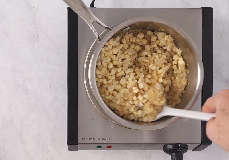overhead shot of a person stirring quinoa in a saucepan