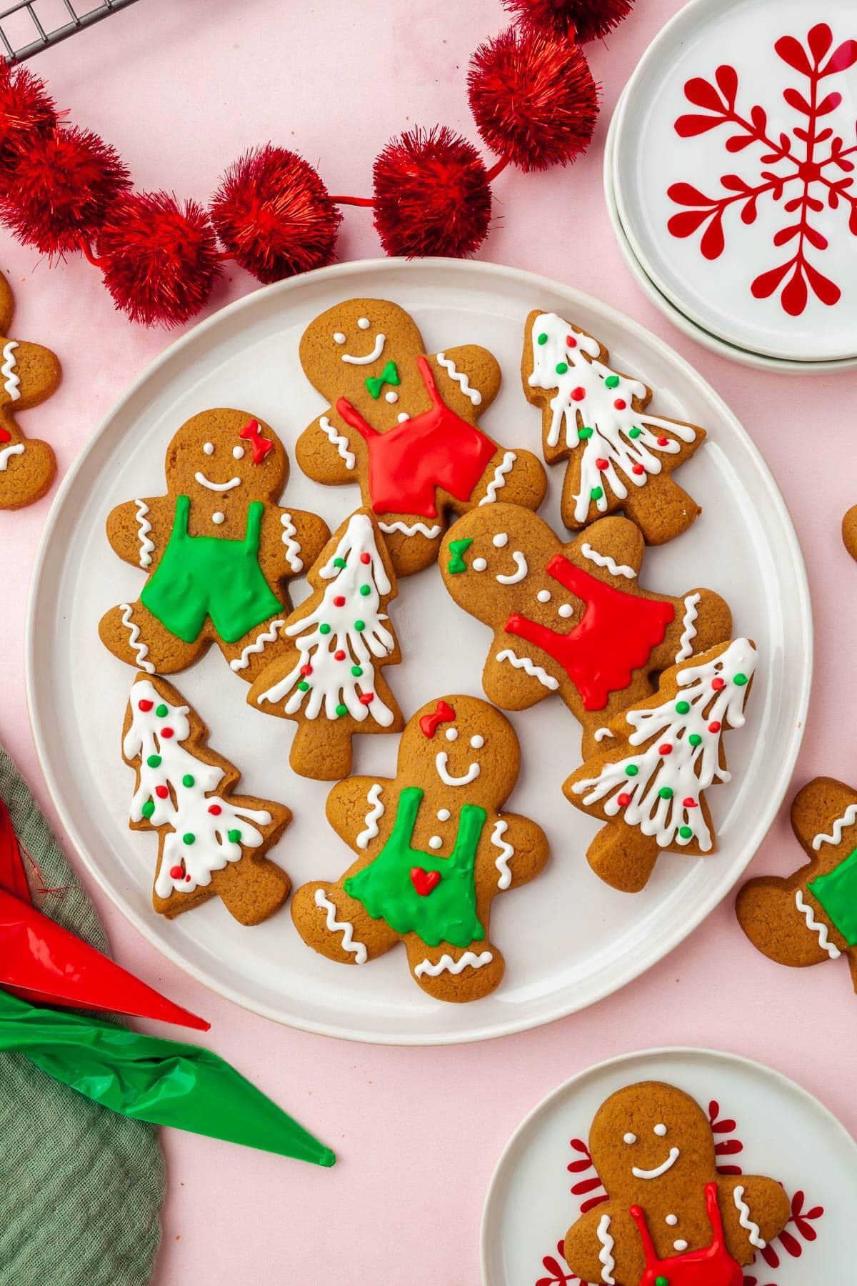 Platter of freshly baked thick frosted gingerbread cookies with holiday decorations