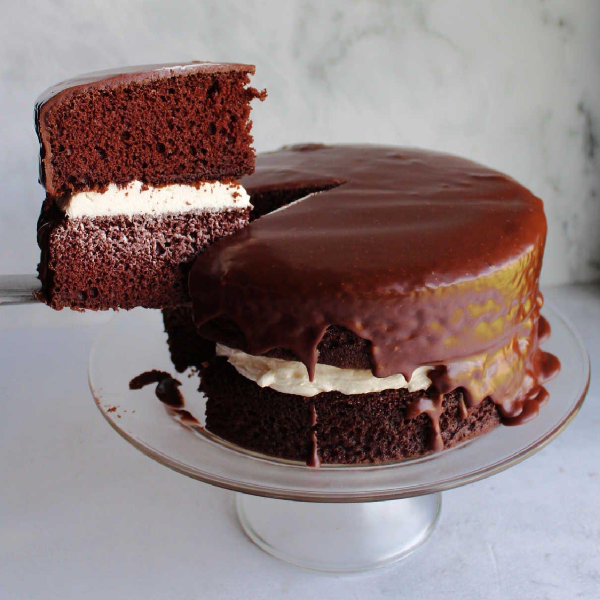 a slice of cake being lifted from the cake with a fork, showing the frosting and pretzel layers