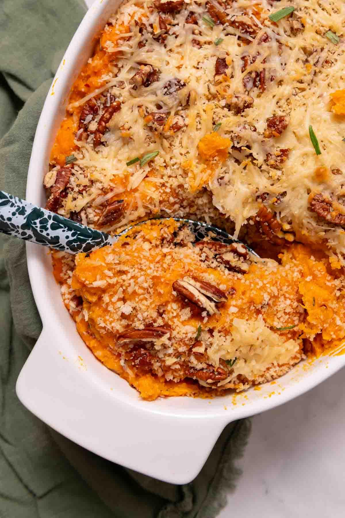 savory sweet potato casserole with rosemary and thyme, close-up, golden crust