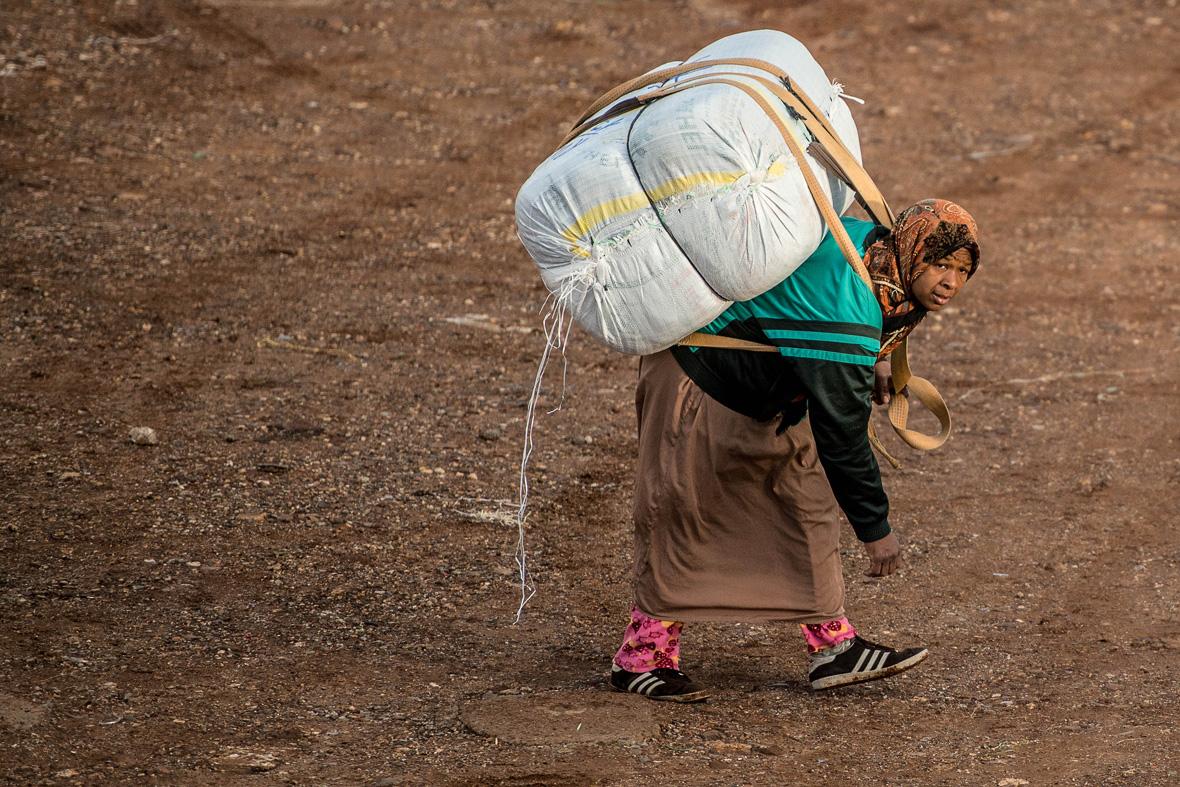woman carrying a heavy backpack on her back