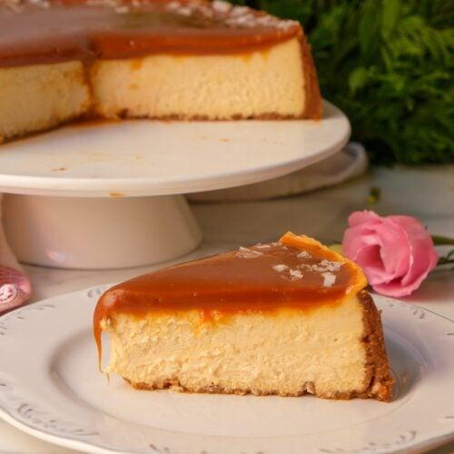Elegant caramel cheesecake slice on a plate, with a fork ready to dig in, festive background