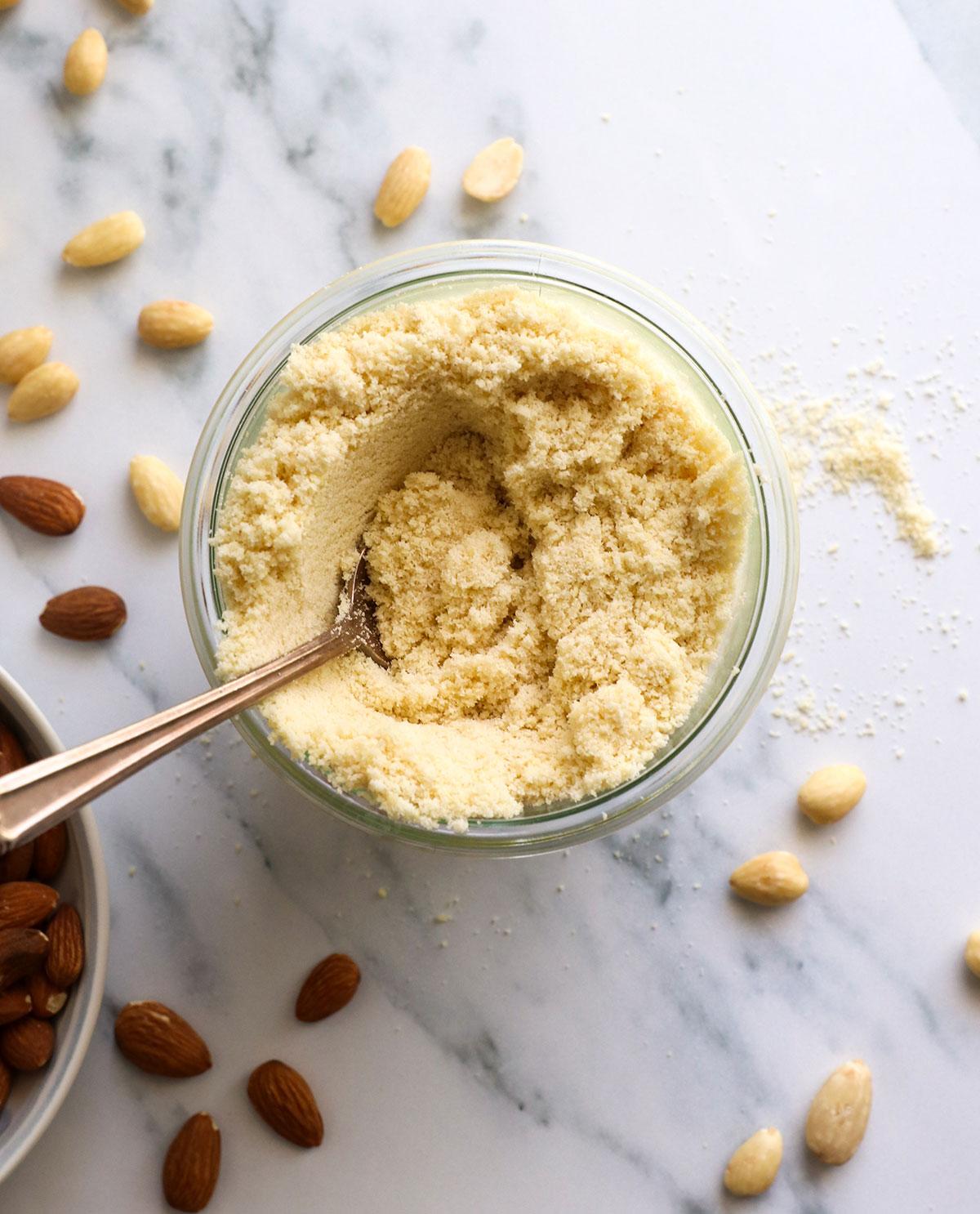 bowls of finely ground almond flour and almond extract on a kitchen counter, ready for baking