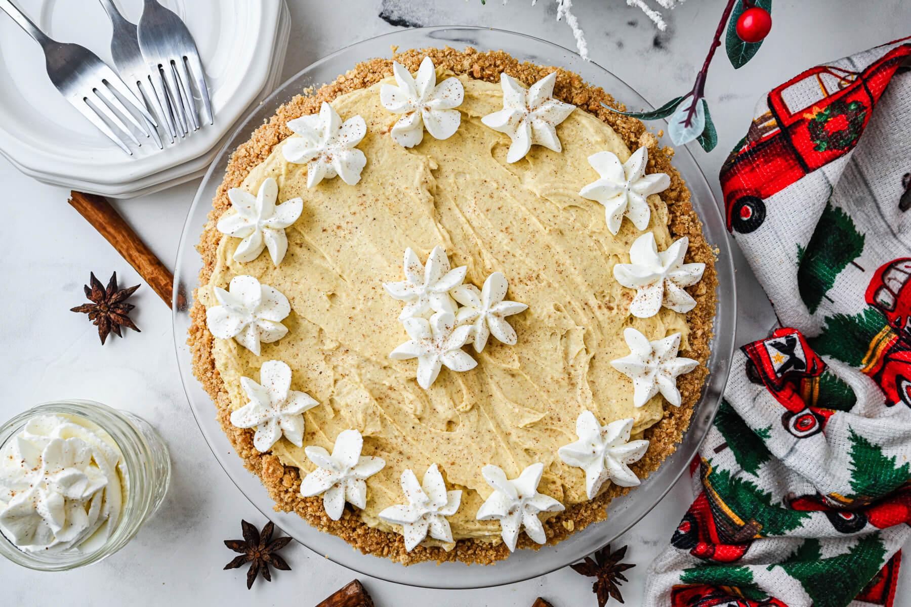 Overhead shot of a whole eggnog pie on a decorative plate, ready to be served